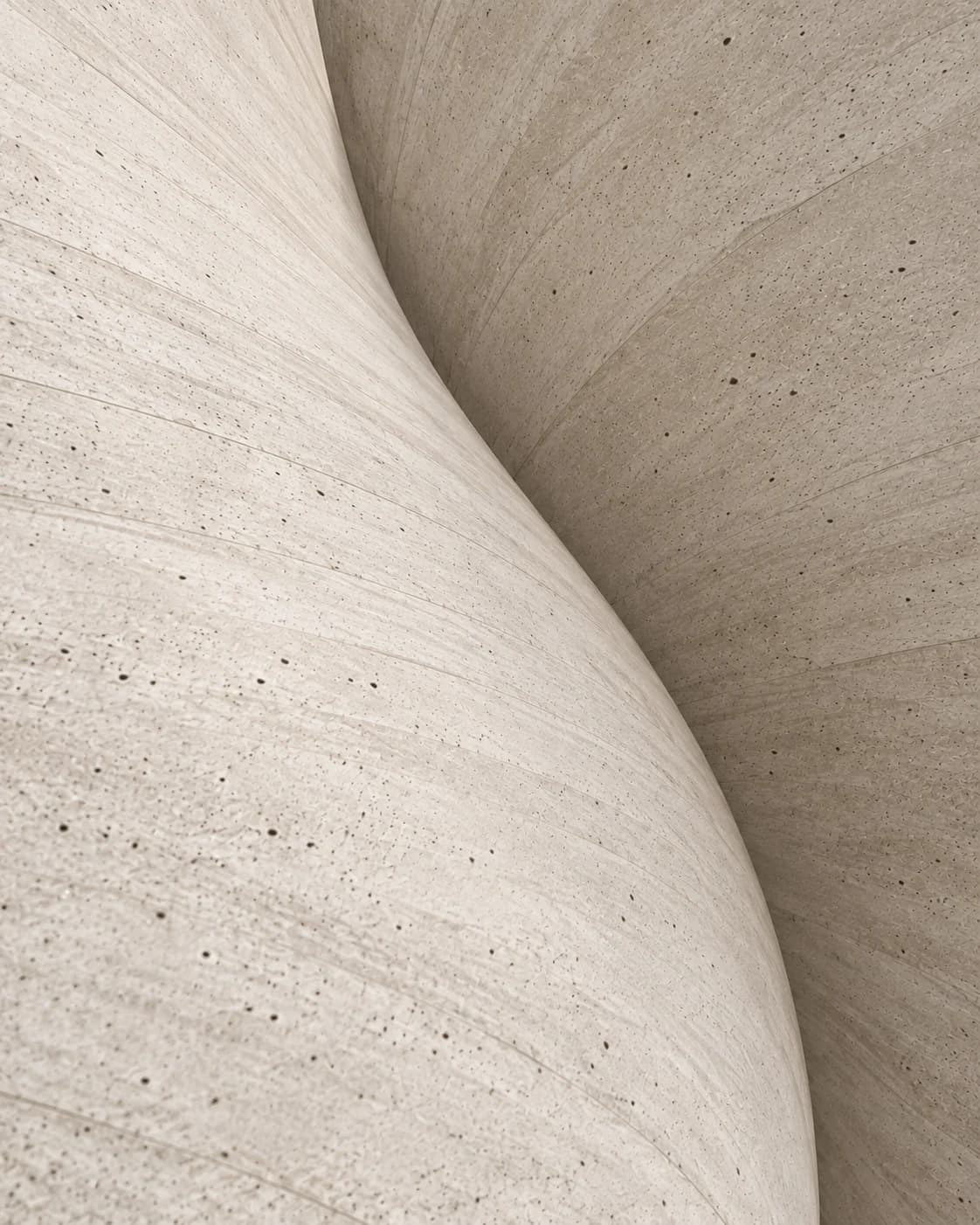 Abstract close view of two curved concrete surfaces meeting along a soft edge.